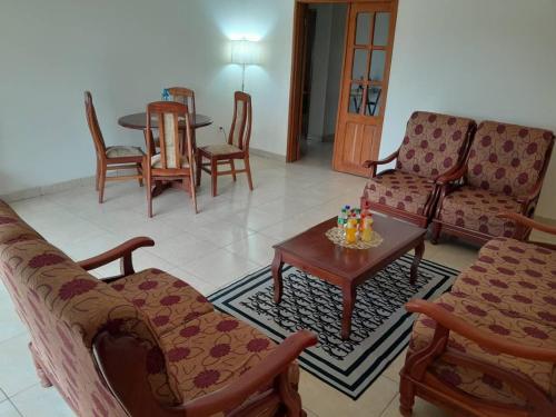 a living room with couches and a table and chairs at Black Diamond Appartements in Kribi