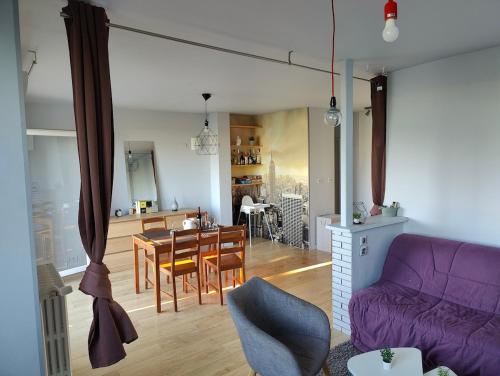 un salon avec un canapé violet et une table dans l'établissement Le nid de la Garonne, à Toulouse