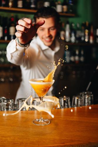 a man standing at a bar making a drink at Hotel de Zeeuwse Stromen - Duinpark in Renesse