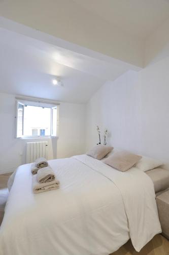 - une chambre blanche avec un grand lit et des serviettes dans l'établissement Superbe appartement & proche mer, à Nice