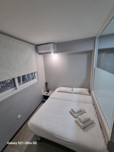 Un dormitorio pequeño con una cama con toallas. en athens.apartotel.box, en Atenas