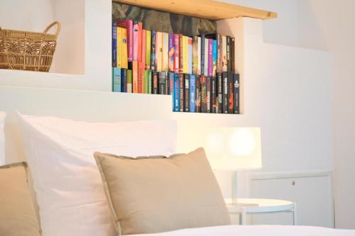 a shelf of books above a bed with a pillow at Ferienwohnung Villa Wagersrott in Wagersrott