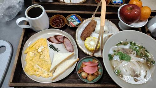 a tray with plates of breakfast food on a table at Guizhou Kaili Leli Designer Hotel in Bainiu