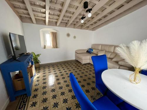 a living room with blue chairs and a table at El Encanto de Jerez in Jerez de la Frontera