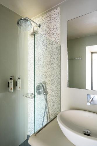 a bathroom with a glass shower and a sink at Andromeda Villas & Spa Resort in Imerovigli