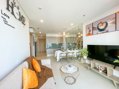 a living room with a couch and a television at Erica's House - Oceanview The Sóng Apartment Vũng Tàu Nghỉ Dưỡng Biển Cao Cấp 5 Sao - The Song Vung Tau Condotel 5 Star Beach View Apartment in Vung Tau