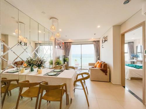 a dining room and living room with a table and chairs at Erica's House - Oceanview The Sóng Apartment Vũng Tàu Nghỉ Dưỡng Biển Cao Cấp 5 Sao - The Song Vung Tau Condotel 5 Star Beach View Apartment in Vung Tau