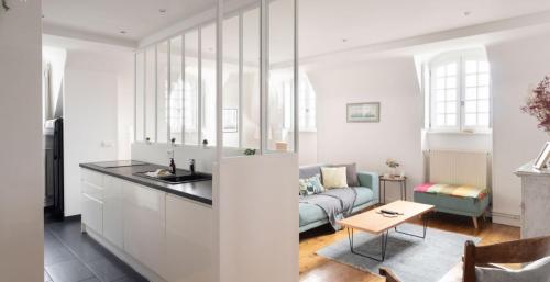 une cuisine et un salon avec un canapé et une table dans l'établissement L écrin de l armateur, à Saint-Malo