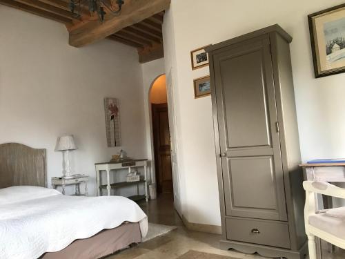 a bedroom with a bed and a cabinet at Domaine du Manoir in Les Avenières