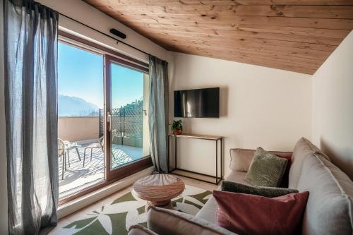 a living room with a couch and a large window at Bella Vita - by MyHomeInComo in Menaggio
