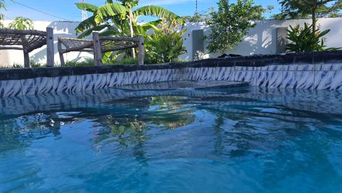 a swimming pool with blue water in front of a house at Villa Liam B&B Kiwengwa Zanzibar in Kumba Urembo