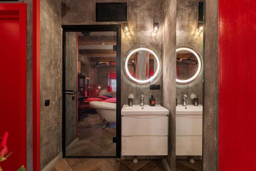 a bathroom with two sinks and a tub and a mirror at Masoch. Hotel & Cafe in Lviv