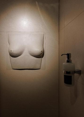 a bathroom with a soap dispenser on a wall at Masoch. Hotel & Cafe in Lviv