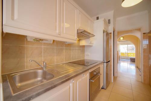 une cuisine avec des armoires blanches et un évier dans l'établissement 2 pieces proche Carnot avec apercu mer A1B244, à Cannes