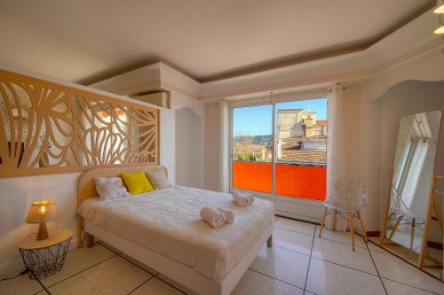 une chambre avec un lit et une grande fenêtre dans l'établissement 2 pieces proche Carnot avec apercu mer A1B244, à Cannes