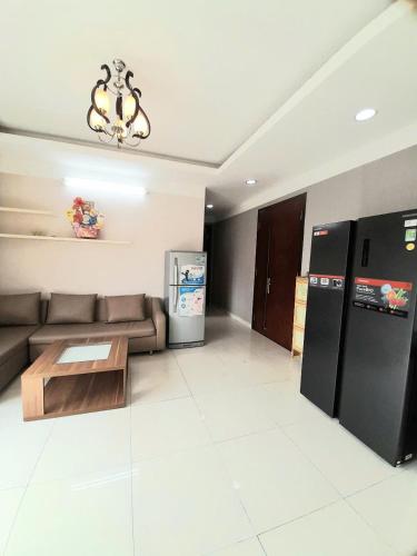 a living room with a couch and a refrigerator at Chung cư sunrise Becamex in Ấp Phú Thọ