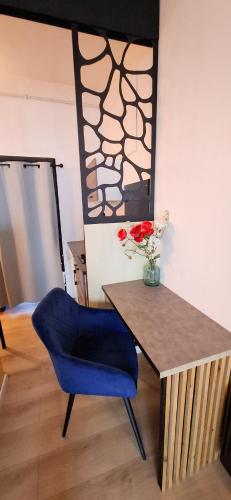 une chaise bleue et une table avec un vase de fleurs dans l'établissement Centre ville cosy 33m2, à Montpellier