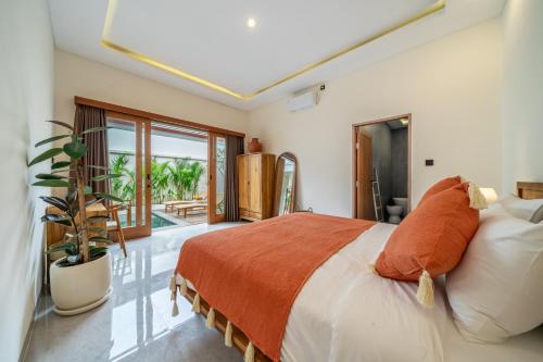 a bedroom with a bed with an orange blanket at Exclusive Luxury Villa with Pool - Your Private Oasis Steps from the City Center! in Kerobokan
