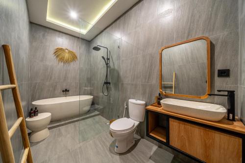 a bathroom with a toilet and a sink and a mirror at Exclusive Luxury Villa with Pool - Your Private Oasis Steps from the City Center! in Kerobokan
