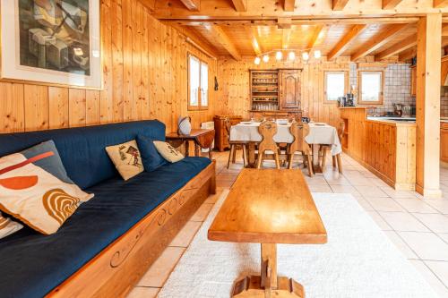 un salon avec un canapé bleu et une table dans l'établissement SmartStay Chalet Diamant - Praz-sur-arly, à Praz-sur-Arly
