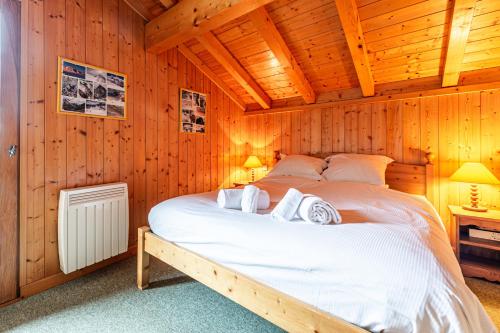 une chambre avec un lit dans une pièce en bois dans l'établissement SmartStay Chalet Diamant - Praz-sur-arly, à Praz-sur-Arly