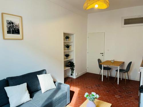 un salon avec un canapé bleu et une table dans l'établissement Studio en plein coeur du Vieil Antibes, vue sur place romantique, à Antibes