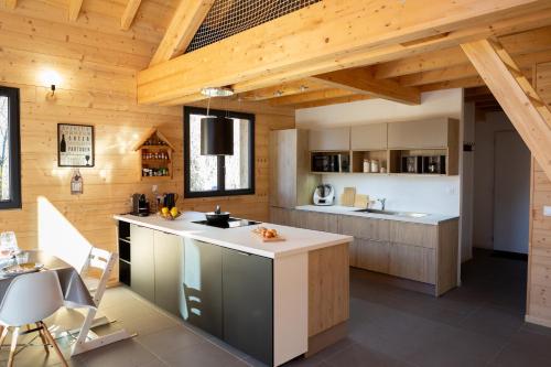an open kitchen with wooden ceilings and a kitchen island at La Tour de l'Enversin in Vaujany