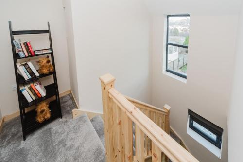 a room with a staircase with a book shelf at Old Kyle Farm - Stunning Views - 2 mins from Skye Bridge in Kyleakin