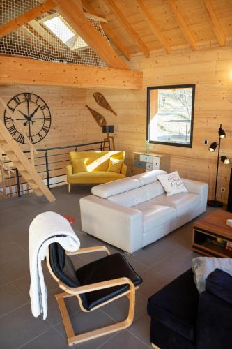 - un salon avec un grand lit et une horloge dans l'établissement La Tour de l'Enversin, à Vaujany