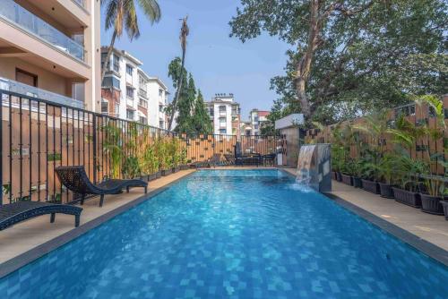 a swimming pool with blue water in a building at Aqua 2 BHK Apartment by tisyastays in Candolim