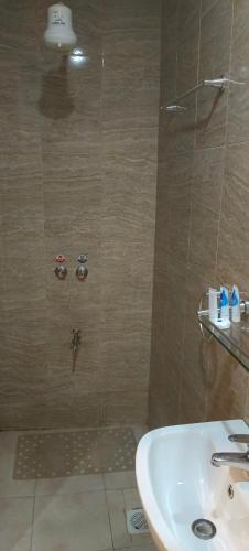 a bathroom with a shower and a sink at Motel Clavina in Gilgil