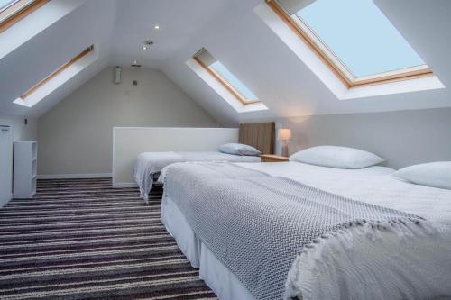 two beds in a attic room with skylights at Ridgeway Retreat - 1 Bedroom Cottage - Manorbier in Manorbier
