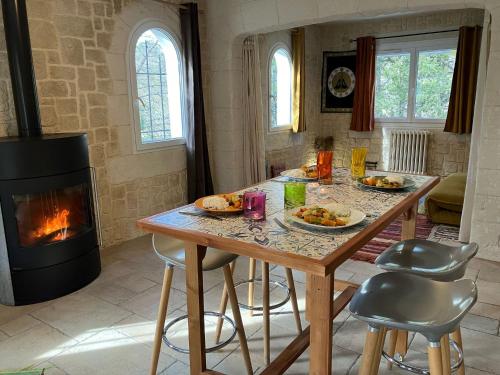 - une cuisine avec une table et une cheminée dans l'établissement Gîte avec jacuzzi, et accès privé à la rivière, à Ladern-sur-Lauquet
