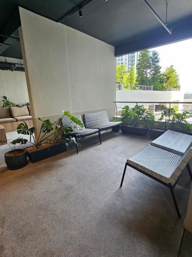 a room with two benches and potted plants at Riqqa Cove Splash Mania Homestay in Banting