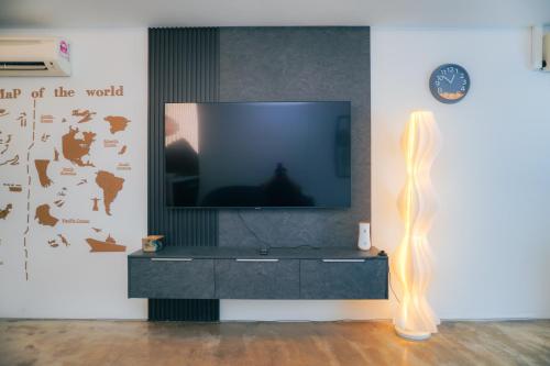 a living room with a tv and a black entertainment center at i-Sovo i-City-3sleep-Netflix-Gym in Shah Alam