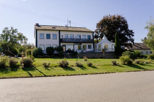 a large white house on a green lawn at Landhaus vor Burg Eltz in Wierschem