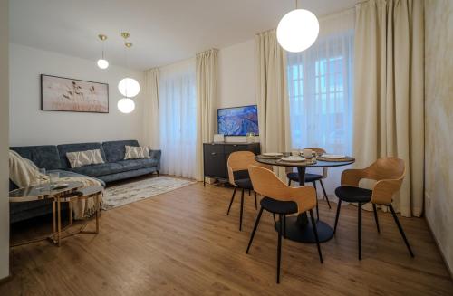 a living room with a couch and a table and chairs at Apartmán v srdci Prahy in Prague