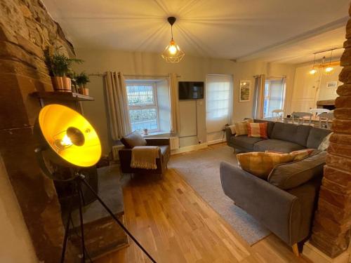 a living room with a couch and a table at Charming 3 bedrooms Cottage in Tirril in Tirril