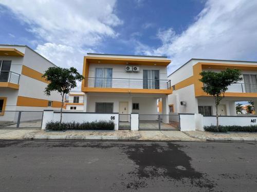 a white and orange building with trees in front of it at Luxury Escape Spacious Stay with Pool and Terrace in Luanda