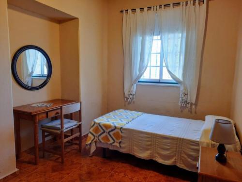 Un dormitorio con una cama y una mesa y una ventana. en La casa de Don Juan, en Puntallana