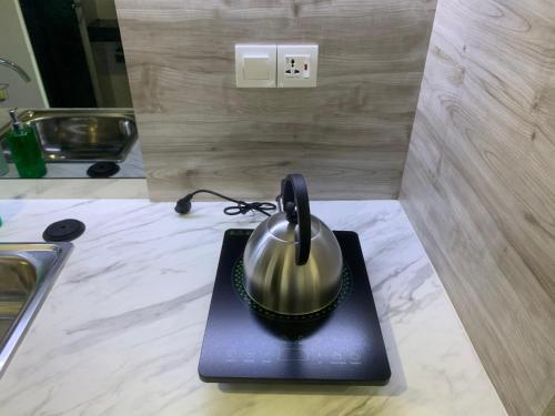 a tea kettle sitting on top of a table at Comfortstay - Citra Plaza Nagoya #31-08 Sea View in Jodoh