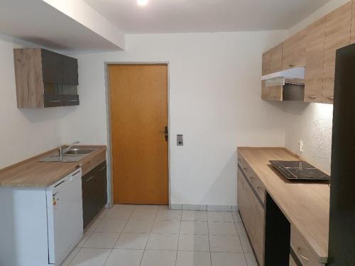 Una cocina con fregadero y puerta de madera. en Nice Apartment in Erlensee, en Erlensee