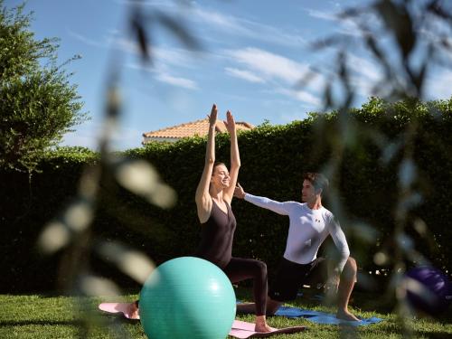 a man and a woman doing a yoga pose at Hotel St John Villas in Tsilivi
