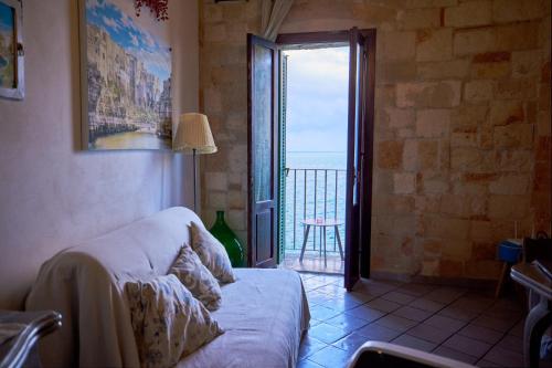 a living room with a couch and a view of the ocean at Dimora Sant'Antonio Polignano a picco sul mare in Polignano a Mare