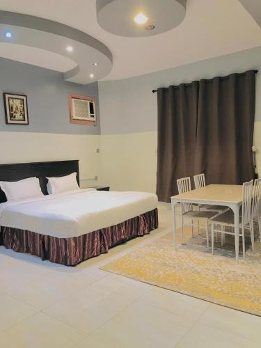 a bedroom with a bed and a table and chairs at شقق سما التميز للشقق المخدومة in Khamis Mushayt