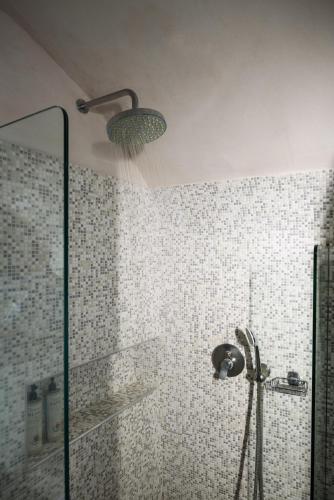 a bathroom with a shower with a glass door at Andromeda Villas & Spa Resort in Imerovigli