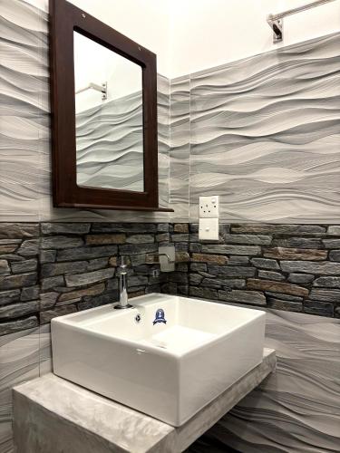 a white sink in a bathroom with a mirror at Heaven's Edge Lodge & Spa in Weligama