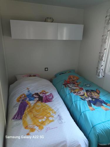 - une chambre avec 2 lits et des draps sur le thème du disque dans l'établissement Mobilhome dans Camping Vias plage, à Vias
