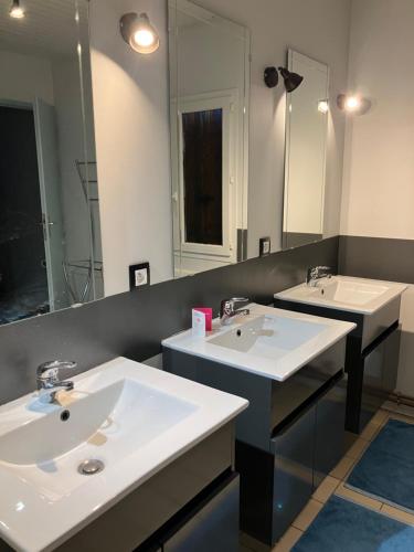 une salle de bain avec deux lavabos et un grand miroir dans l'établissement Maison avec piscine dans airial Landais, à Cudos