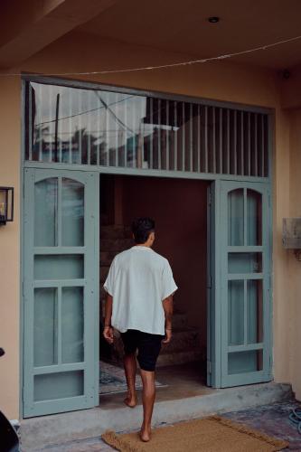 a man walking into an open door at Gitano Surf Ahangama Beachfront in Ahangama